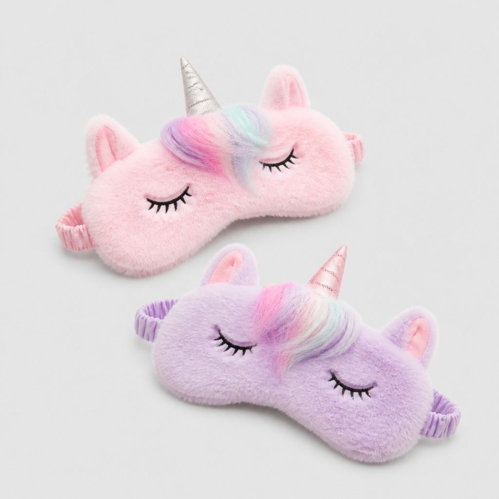 Deux masques de sommeil enfant en peluche posés sur fond clair