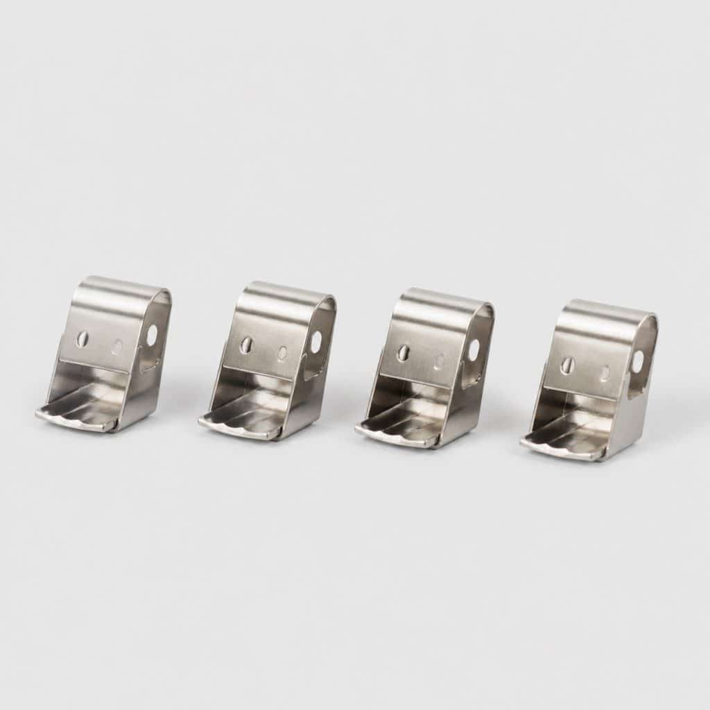 Quatre clips métalliques posés en ligne sur un fond clair
