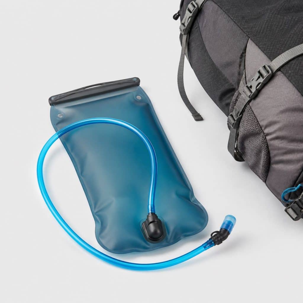Poche à eau souple posée près d'un sac à dos de randonnée