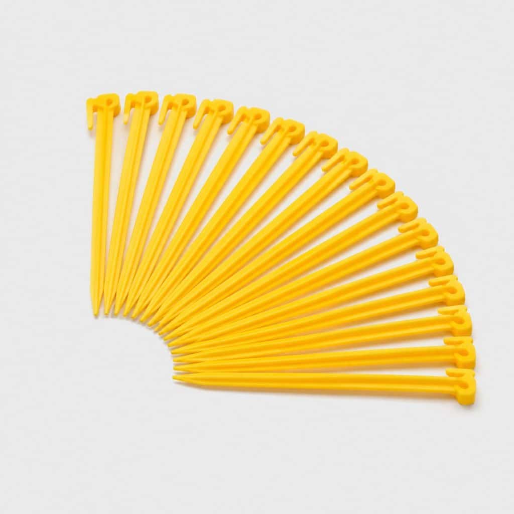 Vingt piquets de tente en plastique jaune sur fond clair
