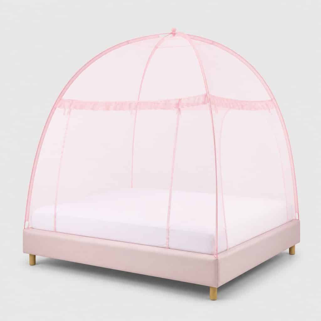 Moustiquaire de lit en dôme rose au-dessus d'un lit