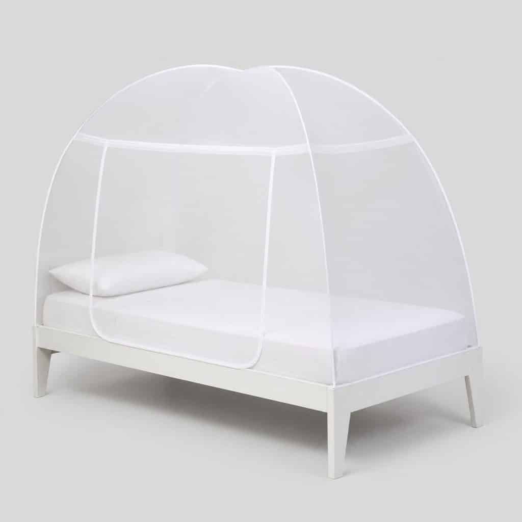 Moustiquaire de lit blanche en dôme au-dessus d'un lit une place